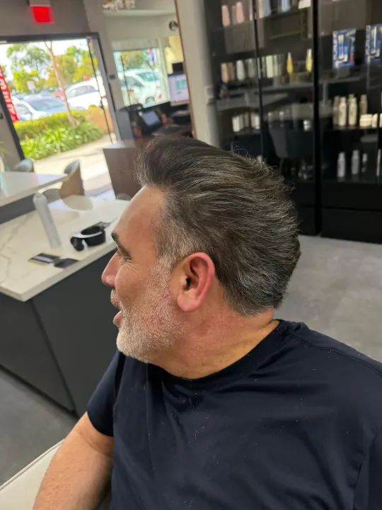A barber shaping a client's haircut