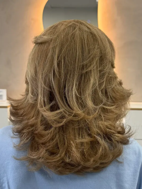 Long blonde hair finished in soft waves at Bliss & Blade