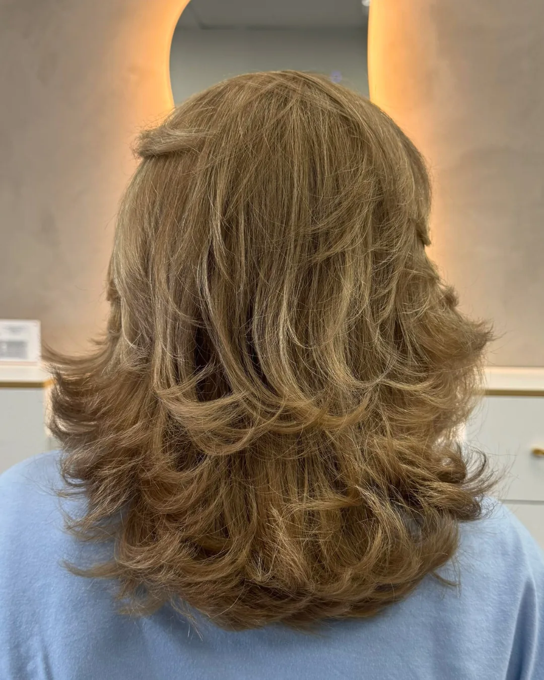 Long golden hair with a curled finish at Bliss & Blade