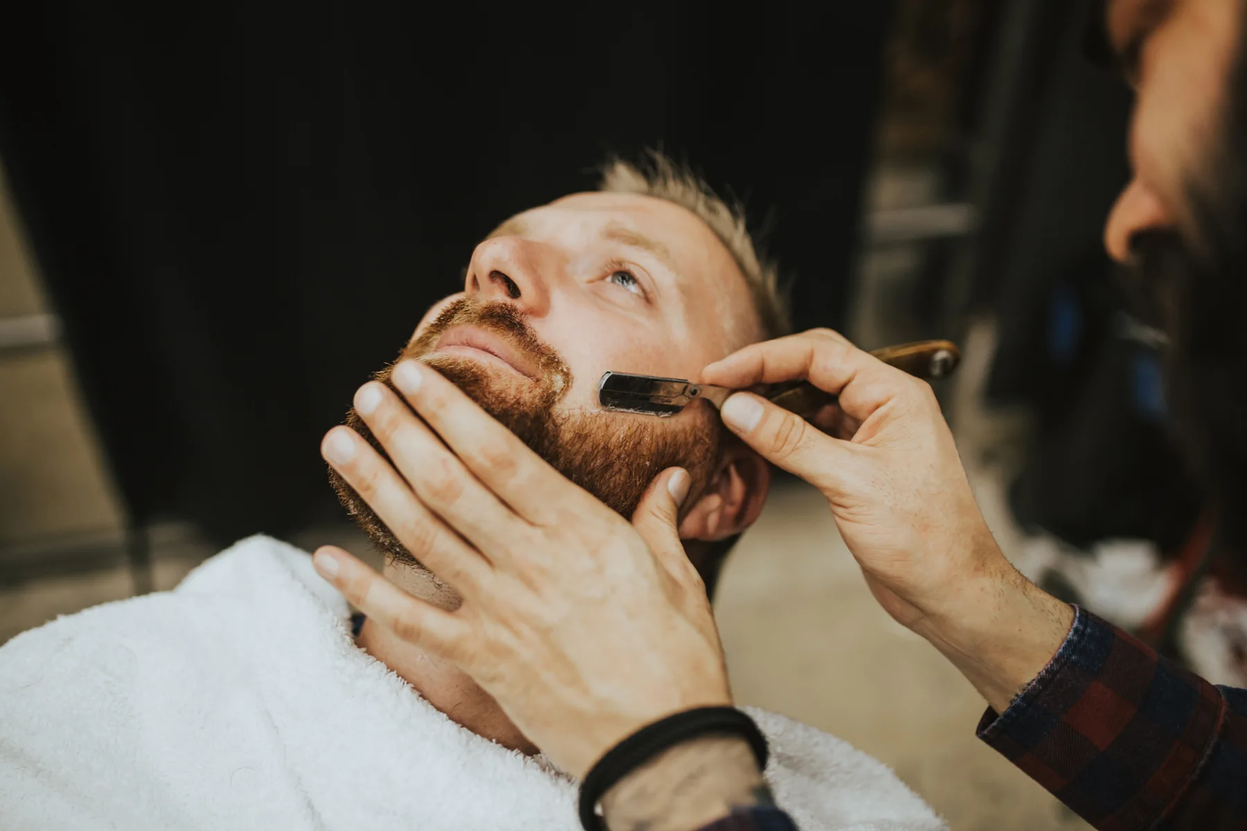 Barber providing a grooming service at Bliss & Blade